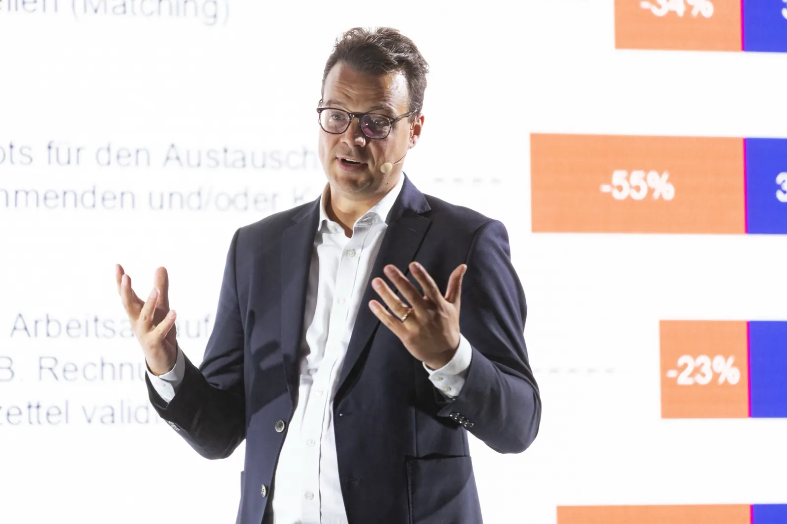 Jens Issel gestikuliert vor einer Folie mit Prozentwerten